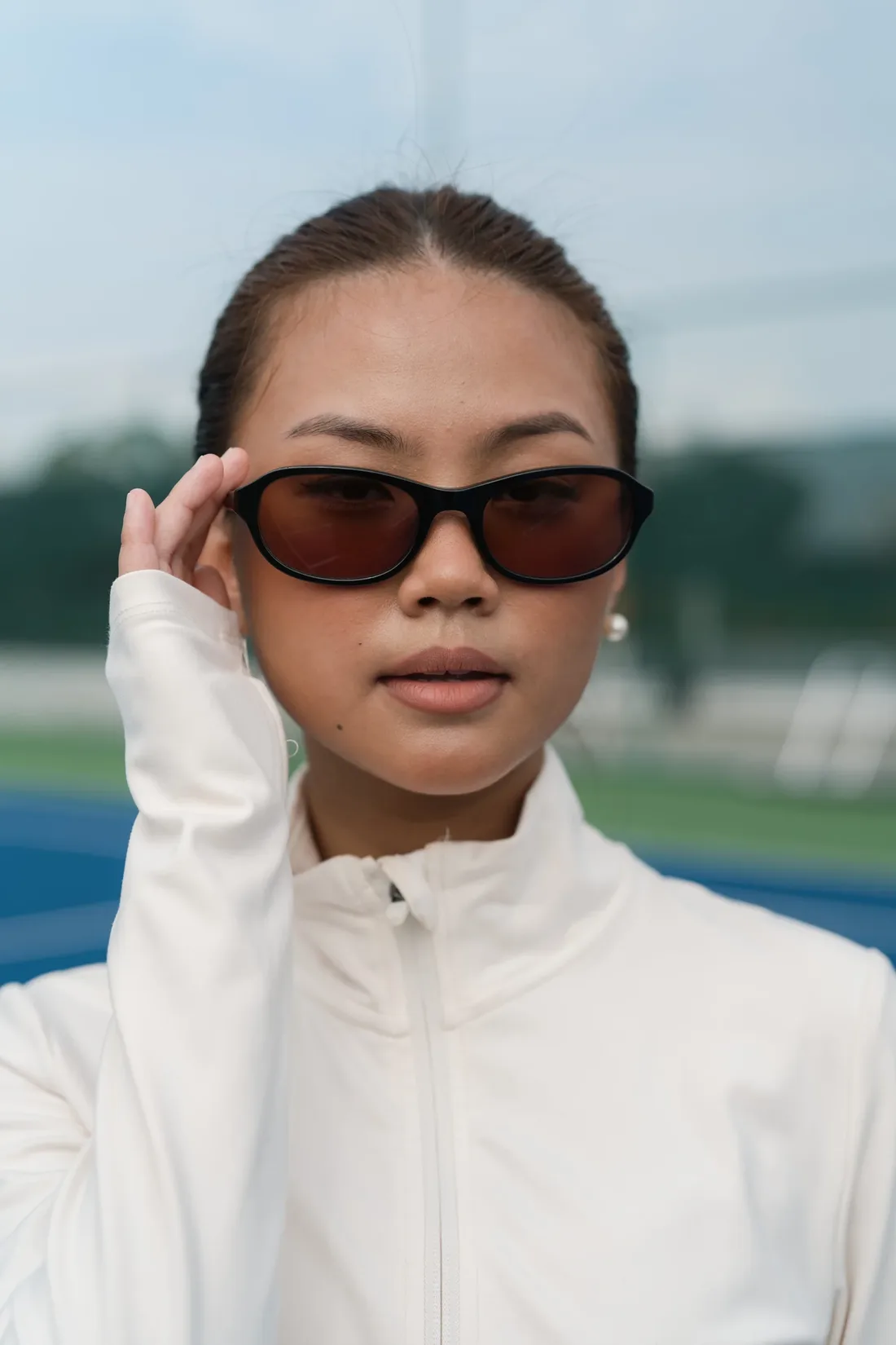 Close-up of Como with amber-red lenses and a white zip jacket